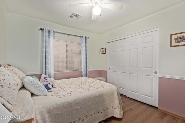 bedroom featuring a closet, visible vents, a ceiling fan, and wood finished floors