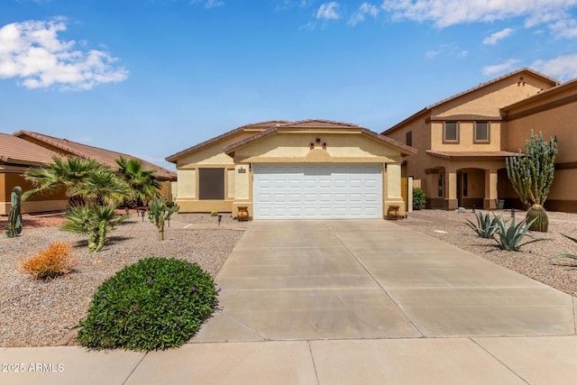 mediterranean / spanish house featuring driveway, stucco siding, and an attached garage