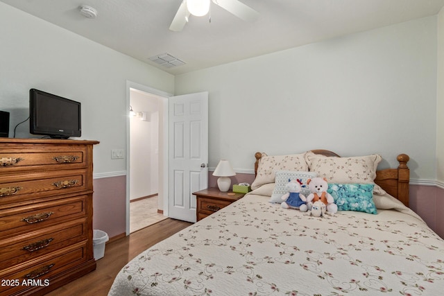 bedroom with dark wood-style floors, visible vents, and a ceiling fan