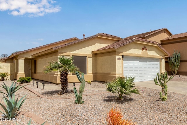 mediterranean / spanish-style house featuring a tile roof, concrete driveway, stucco siding, and an attached garage
