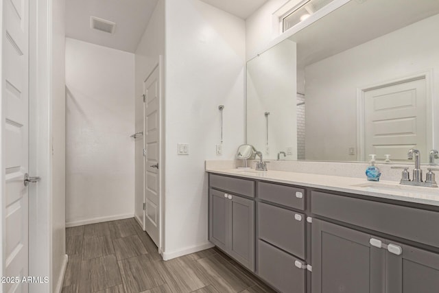full bathroom with visible vents, a sink, baseboards, and double vanity
