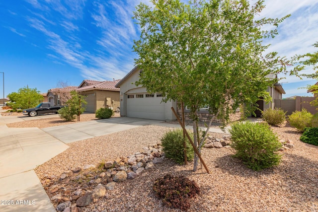 obstructed view of property featuring a tile roof, an attached garage, driveway, and stucco siding