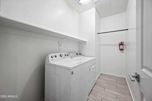 washroom with wood finish floors, laundry area, independent washer and dryer, and baseboards