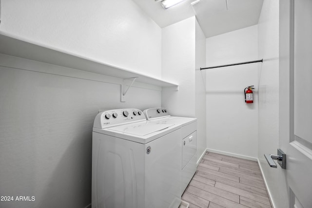 laundry room featuring separate washer and dryer, light wood-style flooring, baseboards, and laundry area