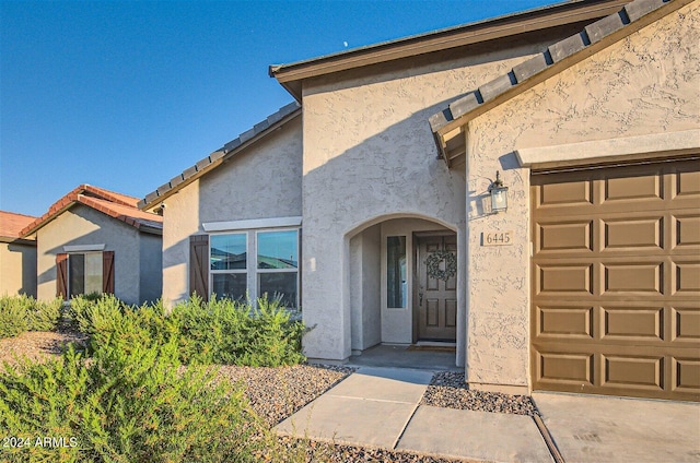 view of exterior entry featuring a garage