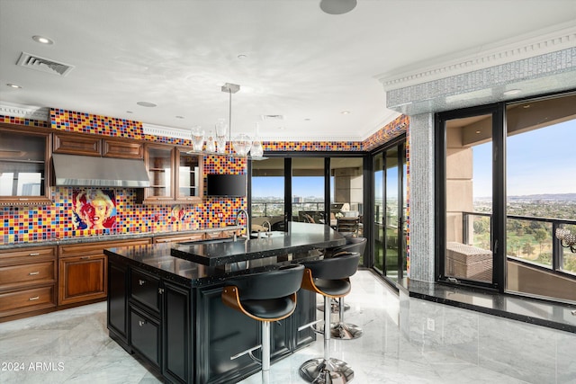 kitchen with plenty of natural light, a kitchen island with sink, a breakfast bar area, and dark stone counters