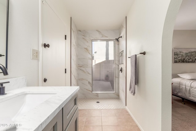 bathroom featuring vanity, a tile shower, and tile patterned flooring