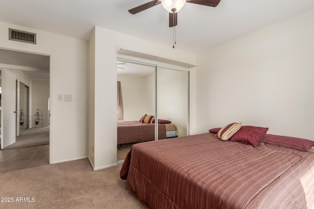 carpeted bedroom with ceiling fan and a closet