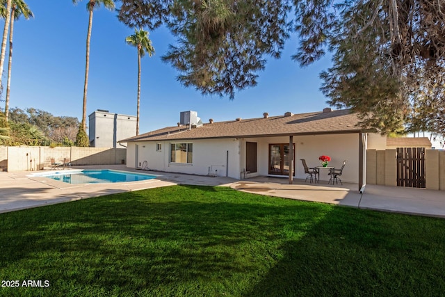 back of house with a fenced in pool, a patio, central AC, and a yard