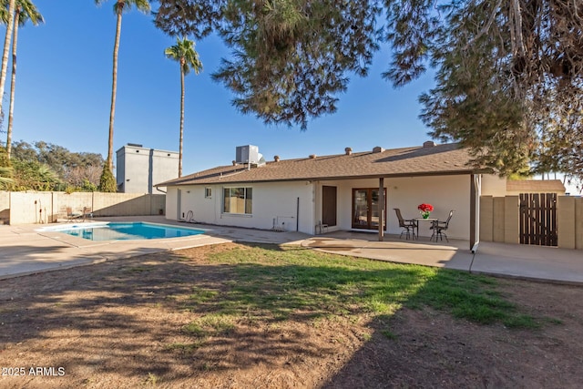 rear view of property with a fenced in pool, central AC unit, and a patio