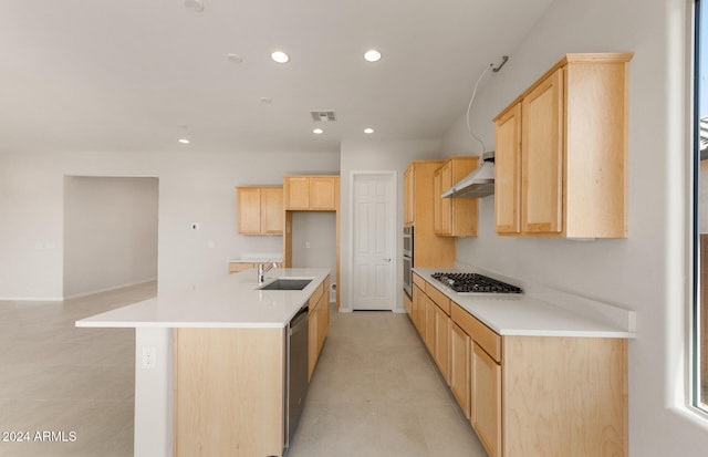 kitchen featuring wall chimney range hood, stainless steel appliances, light brown cabinetry, and sink