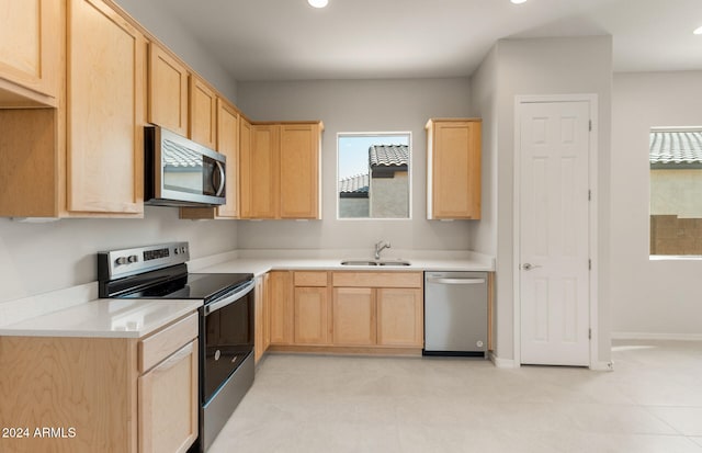 kitchen with light brown cabinets, stainless steel appliances, and sink