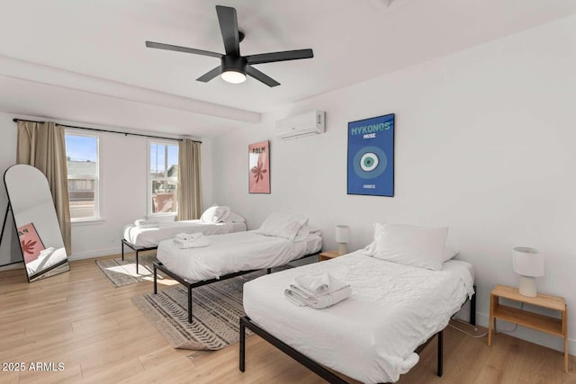 bedroom with ceiling fan, light wood-type flooring, and an AC wall unit