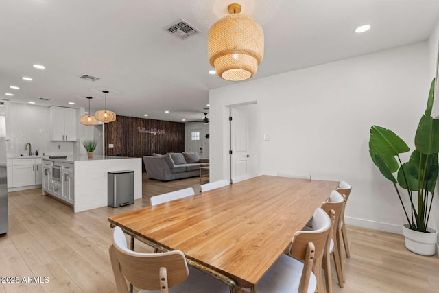 dining area featuring sink, light hardwood / wood-style floors, and ceiling fan