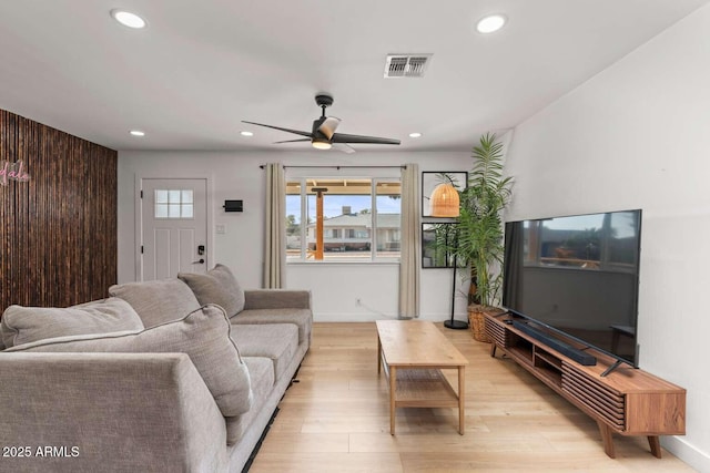 living room with ceiling fan and light hardwood / wood-style flooring