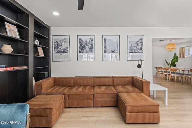 living room featuring built in shelves and light hardwood / wood-style floors