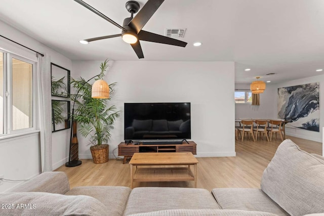 living room featuring ceiling fan and light hardwood / wood-style floors