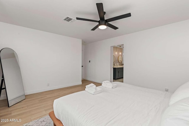 bedroom featuring ceiling fan, ensuite bath, and light wood-type flooring