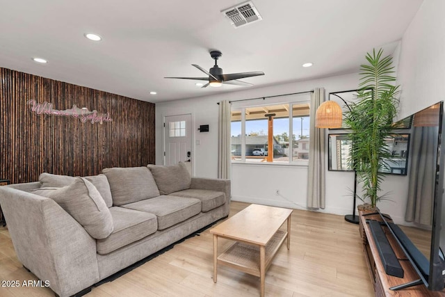 living room featuring light hardwood / wood-style floors and ceiling fan