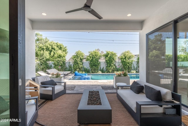 view of patio with ceiling fan and an outdoor living space with a fire pit