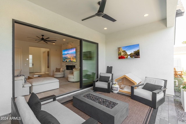 view of patio with an outdoor living space with a fire pit