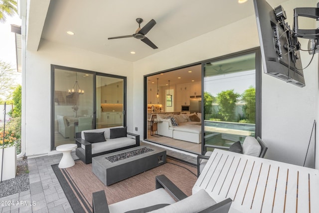 view of patio / terrace with ceiling fan and an outdoor living space with a fire pit