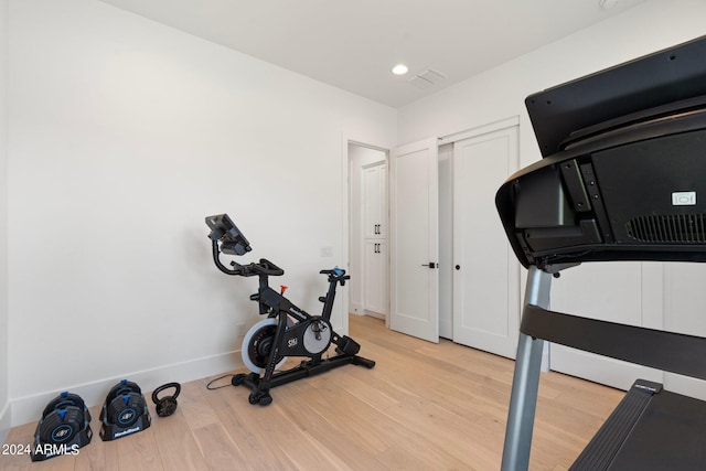 workout room with light hardwood / wood-style flooring