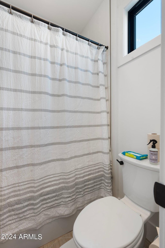 bathroom with a shower with curtain and toilet