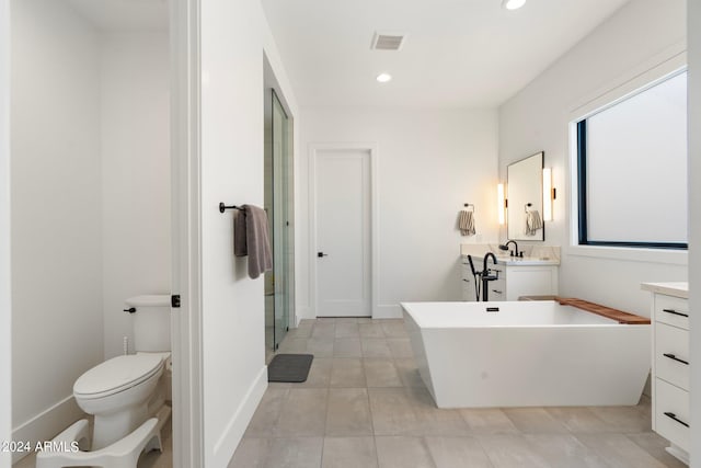 bathroom featuring vanity, toilet, and a tub