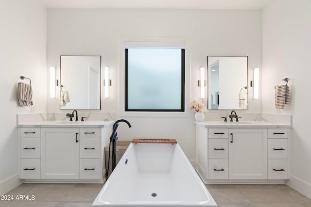 bathroom with tile patterned floors, a bathing tub, and vanity