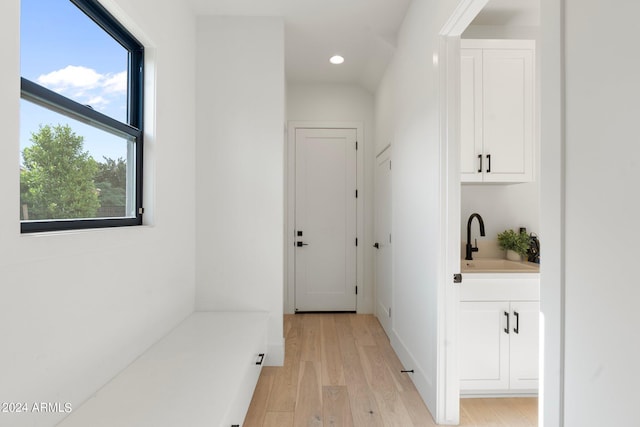 hallway with sink and light wood-type flooring