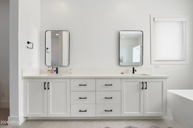 bathroom featuring tile patterned flooring, vanity, and a tub to relax in