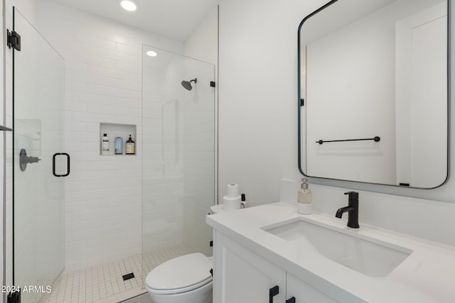 bathroom featuring vanity, a shower with shower door, and toilet