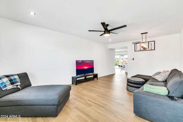 living room with wood-type flooring and ceiling fan with notable chandelier