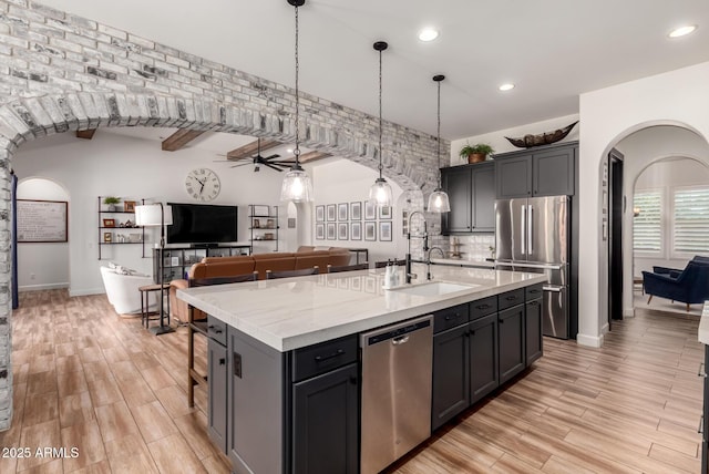 3990 E Iris Dr, Chandler, AZ 85286 - kitchen with appliances with stainless steel finishes, arched walkways, a sink, a ceiling fan, and a center island with sink