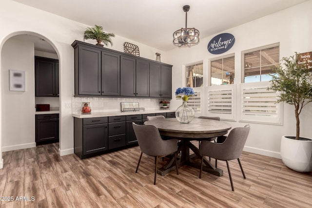 3990 E Iris Dr, Chandler, AZ 85286 - dining room with light wood-style floors, baseboards, and arched walkways