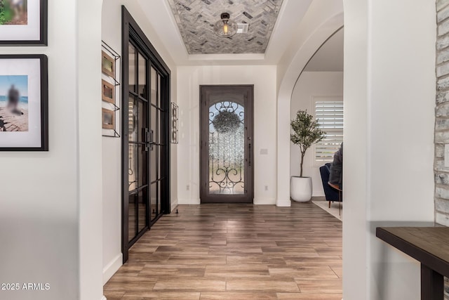 3990 E Iris Dr, Chandler, AZ 85286 - entrance foyer featuring wood finished floors, baseboards, a raised ceiling, and arched walkways