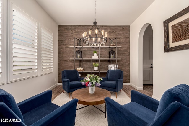 3990 E Iris Dr, Chandler, AZ 85286 - sitting room featuring a chandelier, arched walkways, baseboards, and wood finished floors