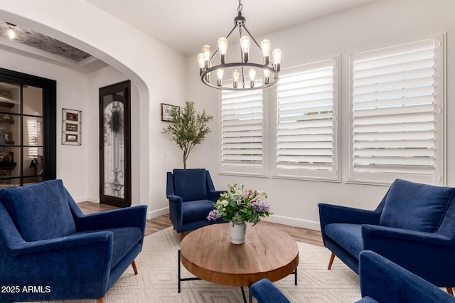 3990 E Iris Dr, Chandler, AZ 85286 - sitting room featuring arched walkways, a chandelier, baseboards, and light wood-style floors