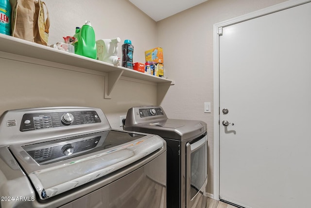 laundry area with light hardwood / wood-style flooring and washing machine and clothes dryer