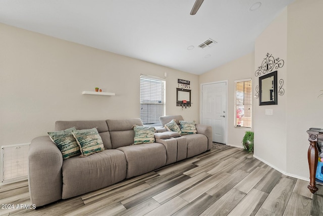 living room with ceiling fan, light hardwood / wood-style floors, and lofted ceiling