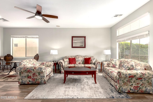 living area featuring a ceiling fan, wood finished floors, and visible vents