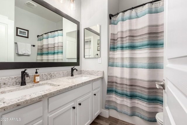 bathroom with double vanity, visible vents, a shower with curtain, and a sink