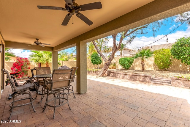 view of patio featuring ceiling fan, outdoor dining area, and a fenced backyard