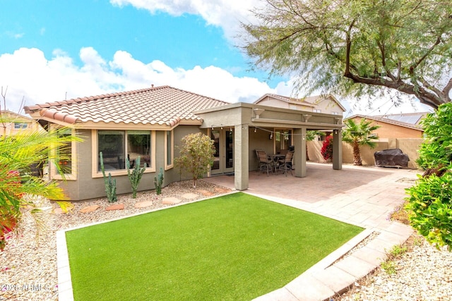 back of house with stucco siding, a tile roof, a patio, and fence