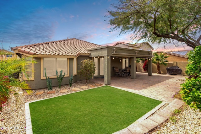 11352 E Starkey Ave, Mesa, AZ 85212 - back of house with fence, stucco siding, a tile roof, a patio, and a lawn
