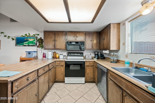 kitchen featuring dishwasher, light tile patterned floors, electric range, and sink