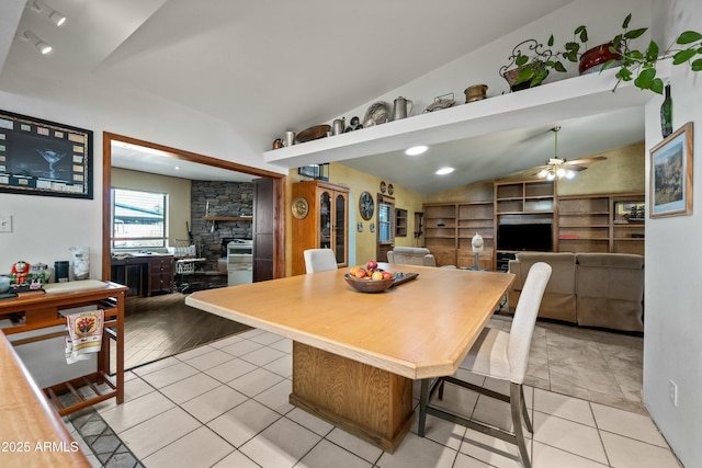 dining room with light tile patterned floors, vaulted ceiling, built in features, and ceiling fan