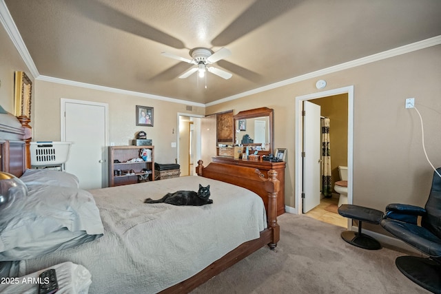 carpeted bedroom with ensuite bath, ceiling fan, a textured ceiling, and ornamental molding