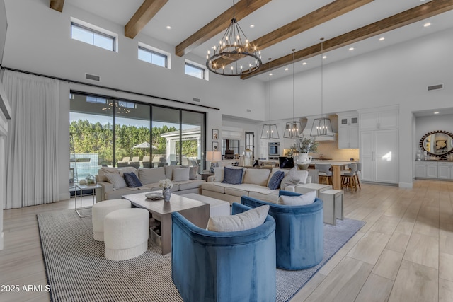 living room featuring a high ceiling, visible vents, a notable chandelier, and beamed ceiling